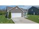 Alluring home features a well-kept lawn, convenient garage, and pleasing landscape stones at 4323 Stubbington Ln, Indianapolis, IN 46239