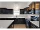 Close up of kitchen with black cabinets, stainless steel appliances, and white countertops at 4323 Stubbington Ln, Indianapolis, IN 46239