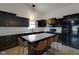 Open kitchen with a large island, black cabinets and bar stool seating at 4323 Stubbington Ln, Indianapolis, IN 46239