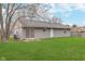 Backyard featuring well-maintained green grass and a gray-sided single-story home at 4326 Burrwood Dr, Indianapolis, IN 46235