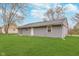 Well-maintained lawn with gray siding on the single-story home and mature trees at 4326 Burrwood Dr, Indianapolis, IN 46235