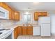 Kitchen features wood cabinets, white appliances, and tile flooring at 4326 Burrwood Dr, Indianapolis, IN 46235