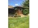 A manicured backyard, featuring a small patio, garden, and lush green lawn at 4329 Dudley N Dr, Indianapolis, IN 46237