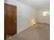 A cozy bedroom with carpet flooring, neutral walls, and a door and window at 4329 Dudley N Dr, Indianapolis, IN 46237