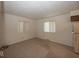 A room with neutral walls, two windows, carpet flooring, and a refrigerator at 4329 Dudley N Dr, Indianapolis, IN 46237