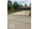 Spacious driveway leading to a single-story brick home with mature trees and a well-maintained lawn at 4329 Dudley N Dr, Indianapolis, IN 46237
