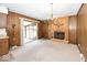 Cozy living room with wood paneling, a brick fireplace, and sliding glass doors to the exterior at 4329 Dudley N Dr, Indianapolis, IN 46237