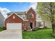 Charming two-story home with a brick facade, attached garage, and manicured lawn at 4546 Creighton Ln, Indianapolis, IN 46237