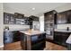 Modern kitchen with dark cabinetry, stainless steel appliances, and a center island at 4546 Creighton Ln, Indianapolis, IN 46237
