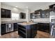 Well-lit kitchen showcasing a center island, dark wood cabinets, and stainless steel dishwasher at 4546 Creighton Ln, Indianapolis, IN 46237