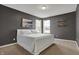Main bedroom with a large bed, gray walls, and two bright windows at 4546 Creighton Ln, Indianapolis, IN 46237