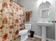 Cozy bathroom featuring a pedestal sink, toilet, and shower with a decorative curtain at 4638 W Otway Ln, New Palestine, IN 46163