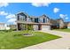 Beautiful two-story home with lush green lawn, mature tree, brick accents, and an attached two-car garage at 4638 W Otway Ln, New Palestine, IN 46163