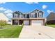 Charming two-story home featuring blue siding, brick accents, a well-manicured lawn, and a spacious two-car garage at 4638 W Otway Ln, New Palestine, IN 46163