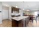 Well-lit kitchen with a center island, dining table, and an open layout to the living area at 4638 W Otway Ln, New Palestine, IN 46163