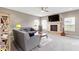 Bright living room with neutral walls, fireplace, ceiling fan, and comfortable gray couches at 4638 W Otway Ln, New Palestine, IN 46163