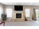 Well-lit living room with a stone fireplace, large windows, and a sliding glass door to the exterior at 4638 W Otway Ln, New Palestine, IN 46163