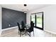The dining room boasts modern lighting, a glass table with seating for four, and sliding doors to a backyard deck at 5302 E 46Th St, Indianapolis, IN 46226