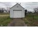 A detached garage with a single, white door, concrete driveway and white siding at 5428 Speedway Dr, Indianapolis, IN 46224