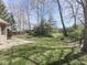 Large backyard with lush green lawn, scattered trees, and a glimpse of the house's exterior at 5461 Steven Dr, Greenwood, IN 46142