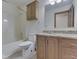 Bright bathroom with granite countertop, wood cabinets, and combination tub and shower at 5461 Steven Dr, Greenwood, IN 46142