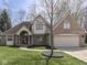 Inviting two-story brick home featuring an attached garage and a well-kept lawn at 5461 Steven Dr, Greenwood, IN 46142