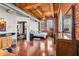 Bright bedroom includes a ceiling fan, hardwood floors, exposed brick, and a view of connecting living spaces at 55 S Harding St # 301, Indianapolis, IN 46222