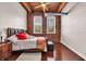 Cozy bedroom featuring exposed brick and wood-beamed ceiling, with bright natural light at 55 S Harding St # 301, Indianapolis, IN 46222