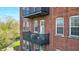 Brick apartment building featuring open-air balconies with dark metal railings and outdoor furniture at 55 S Harding St # 301, Indianapolis, IN 46222