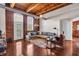 Bright and airy living room with exposed brick wall, hardwood floors and wood beamed ceiling at 55 S Harding St # 301, Indianapolis, IN 46222
