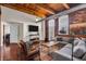 Comfortable living room with large windows, exposed brick, and wood-beamed ceilings at 55 S Harding St # 301, Indianapolis, IN 46222