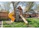 Fun backyard featuring a wooden playset with slides, swings, and a playhouse at 5619 Carrollton Ave, Indianapolis, IN 46220