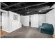Finished basement featuring exposed beams, sliding barn door and painted white brick at 5619 Carrollton Ave, Indianapolis, IN 46220