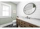 Charming bathroom with shiplap walls, round mirror, and wood vanity with marble countertop at 5619 Carrollton Ave, Indianapolis, IN 46220
