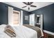 Comfortable bedroom with dark blue walls, a ceiling fan, a patterned rug, and a king bed at 5619 Carrollton Ave, Indianapolis, IN 46220