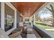 Cozy front porch features comfortable seating, a hanging swing, and a stained wood ceiling at 5619 Carrollton Ave, Indianapolis, IN 46220