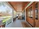 The charming porch has wooden accents, a welcoming sitting area, and stylish decor at 5619 Carrollton Ave, Indianapolis, IN 46220