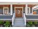 The beautiful front porch features a stained wood ceiling, front door, and manicured landscape at 5619 Carrollton Ave, Indianapolis, IN 46220