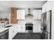 Modern kitchen featuring stainless steel appliances, subway tile, a brick accent, and crisp white cabinetry at 5619 Carrollton Ave, Indianapolis, IN 46220