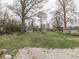Expansive grassy backyard with mature trees and planting beds at 57 Worman St, Indianapolis, IN 46227
