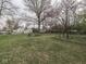 Expansive grassy backyard with mature trees, planting beds and outdoor seating area at 57 Worman St, Indianapolis, IN 46227