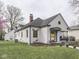 Lovely home with a covered porch, well-maintained lawn, and a detached garage at 57 Worman St, Indianapolis, IN 46227