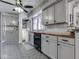 A charming kitchen featuring gray cabinets, wood countertops, and unique patterned tile flooring at 57 Worman St, Indianapolis, IN 46227
