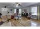 Bright living room featuring hardwood floors, a ceiling fan, and windows with charming yellow curtains at 57 Worman St, Indianapolis, IN 46227