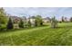 Spacious backyard showcasing a lush green lawn and mature trees for privacy at 5869 Belchamp Dr, Noblesville, IN 46062