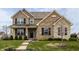 Inviting two-story brick home with a well-manicured lawn and charming front porch at 5869 Belchamp Dr, Noblesville, IN 46062