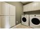 Bright laundry room with white cabinets, modern washer and dryer, and light tile floor at 5869 Belchamp Dr, Noblesville, IN 46062