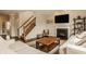 Bright living room with a fireplace, wooden stairs, and comfortable seating arrangement at 5869 Belchamp Dr, Noblesville, IN 46062
