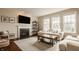 Cozy living room featuring a fireplace, large windows, and comfortable furnishings at 5869 Belchamp Dr, Noblesville, IN 46062