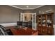 Spacious office with custom wooden cabinet, french doors and hardwood flooring at 5869 Belchamp Dr, Noblesville, IN 46062